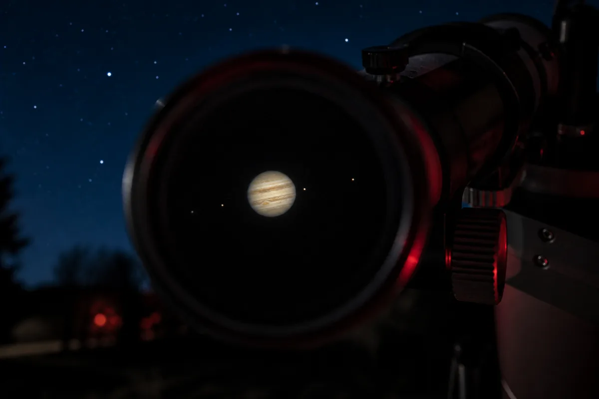 Jupiter et ses bandes nuageuses observées dans l&rsquo;oculaire d&rsquo;un télescope, satellites alignés