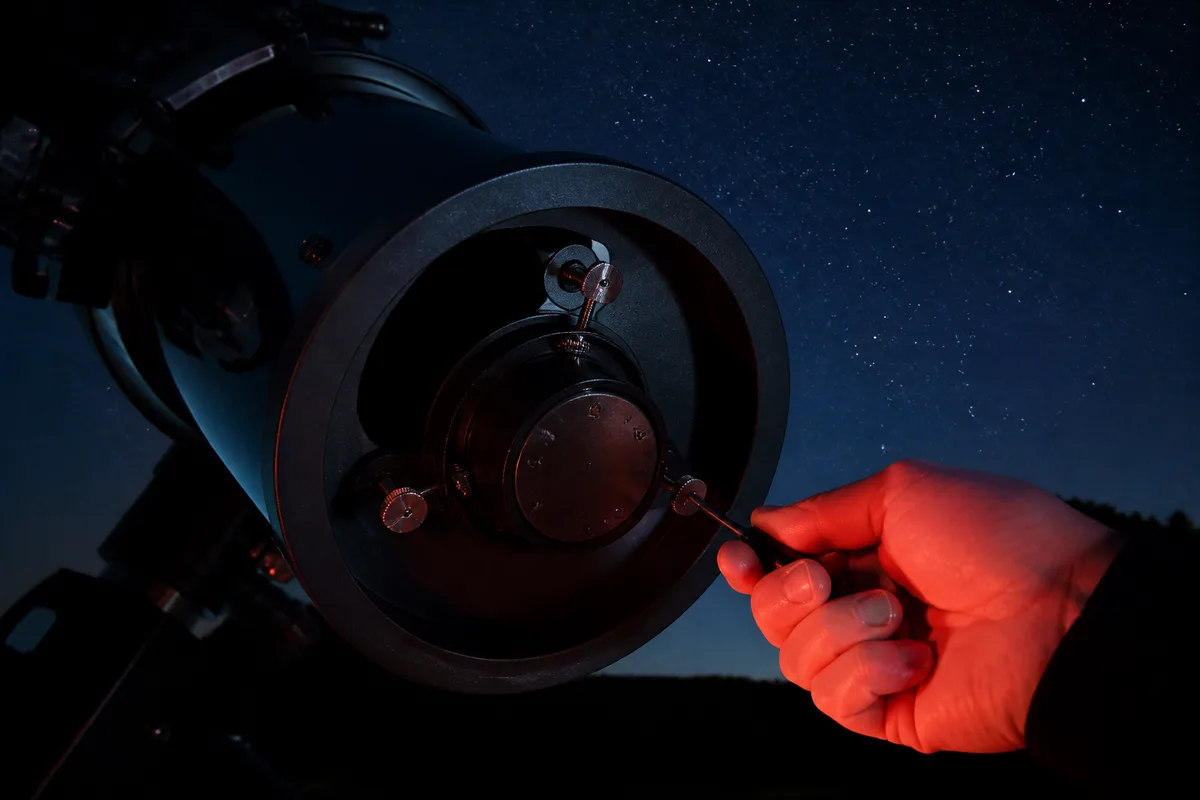Réglage des vis de collimation à l&rsquo;arrière d&rsquo;un télescope de Newton, tournevis à la main