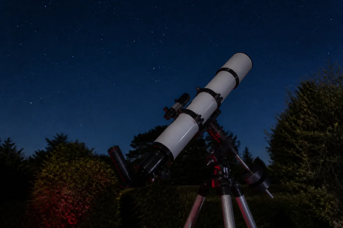 Télescope de 200 mm installé dans un jardin sombre, oculaire prêt à l’observation